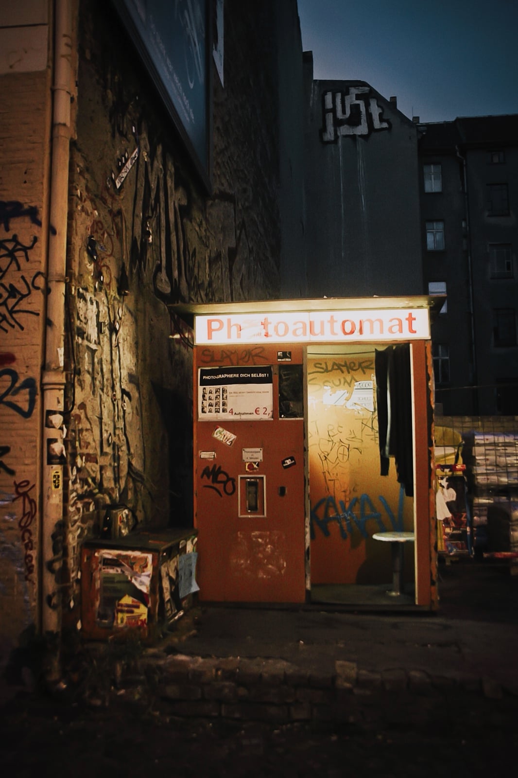 photo booth and its illuminated sign in a Berlin street at night