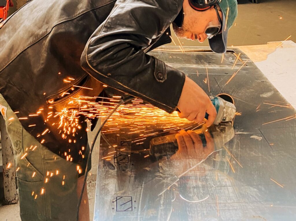 man cutting metal sparks 