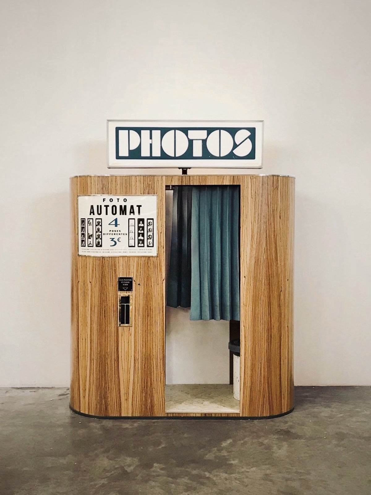 wooden photo booth with a lighted sign and a blue curtain