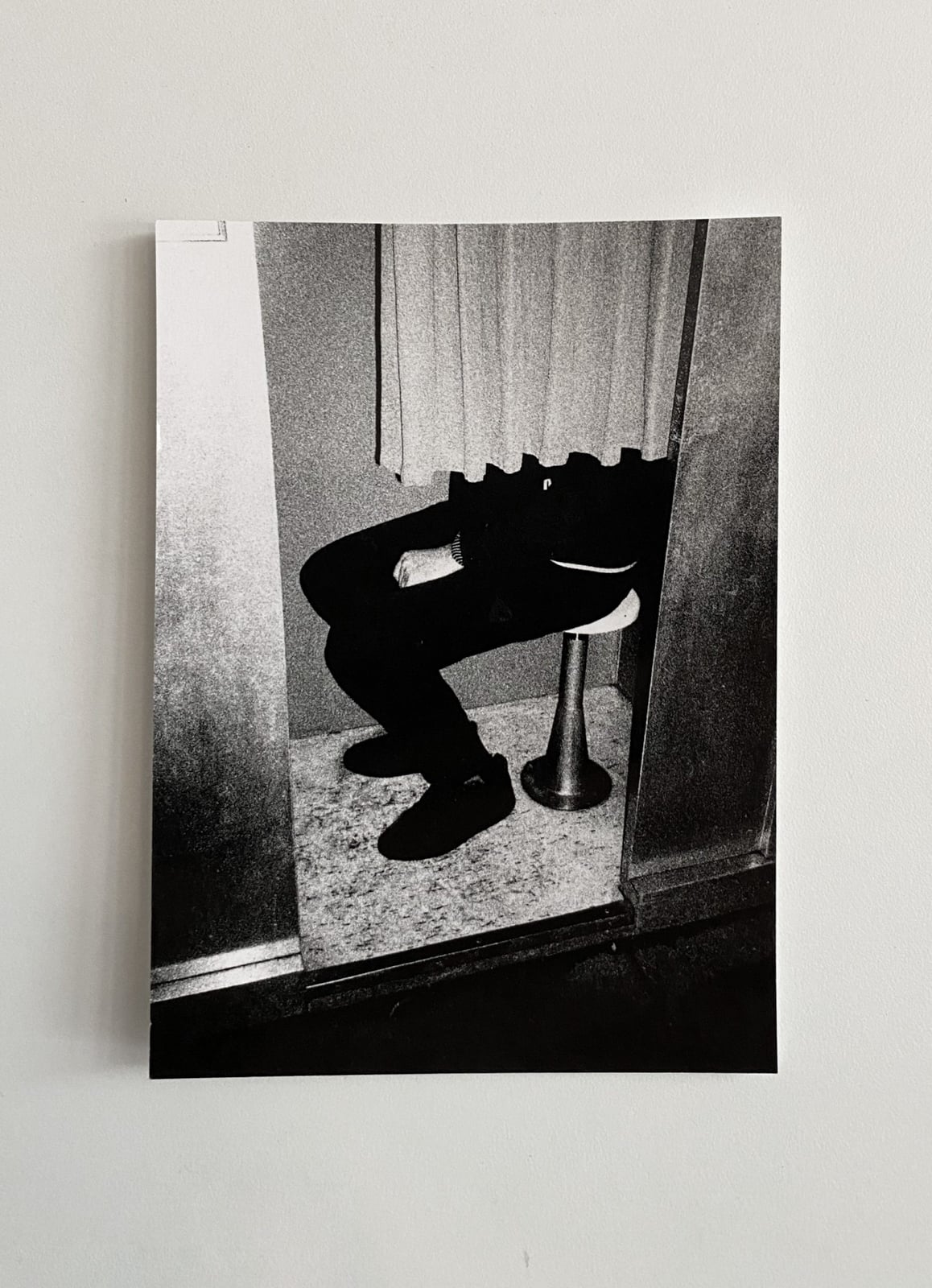 carte postale en noir et blanc d'un homme assis dans un photomaton