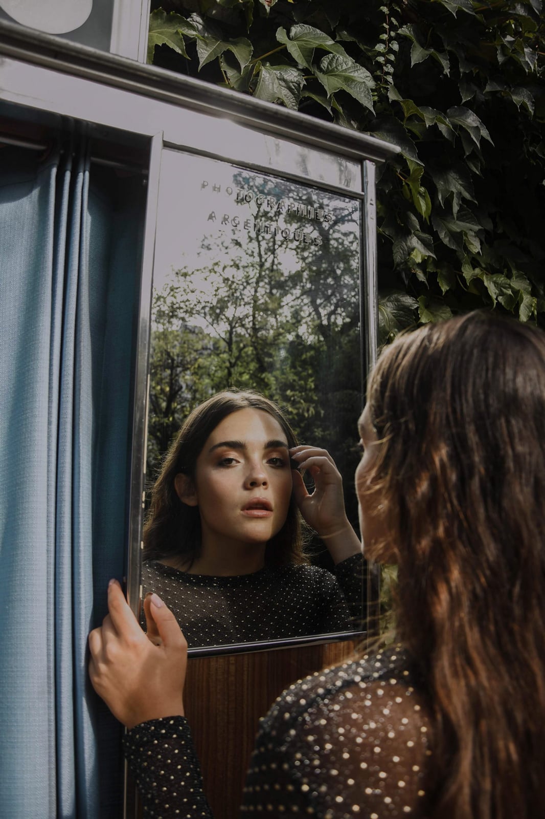 femme se regardant dans un miroir de photomaton