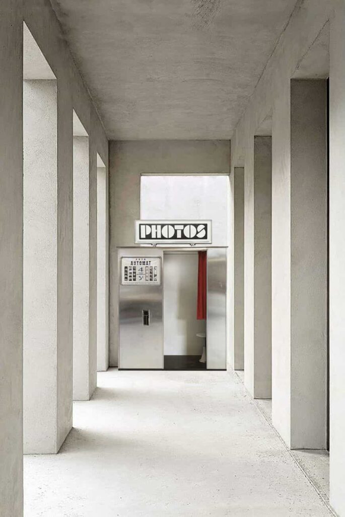 photomaton en métal dans le couloir d'un bâtiment en béton avec des colonnes